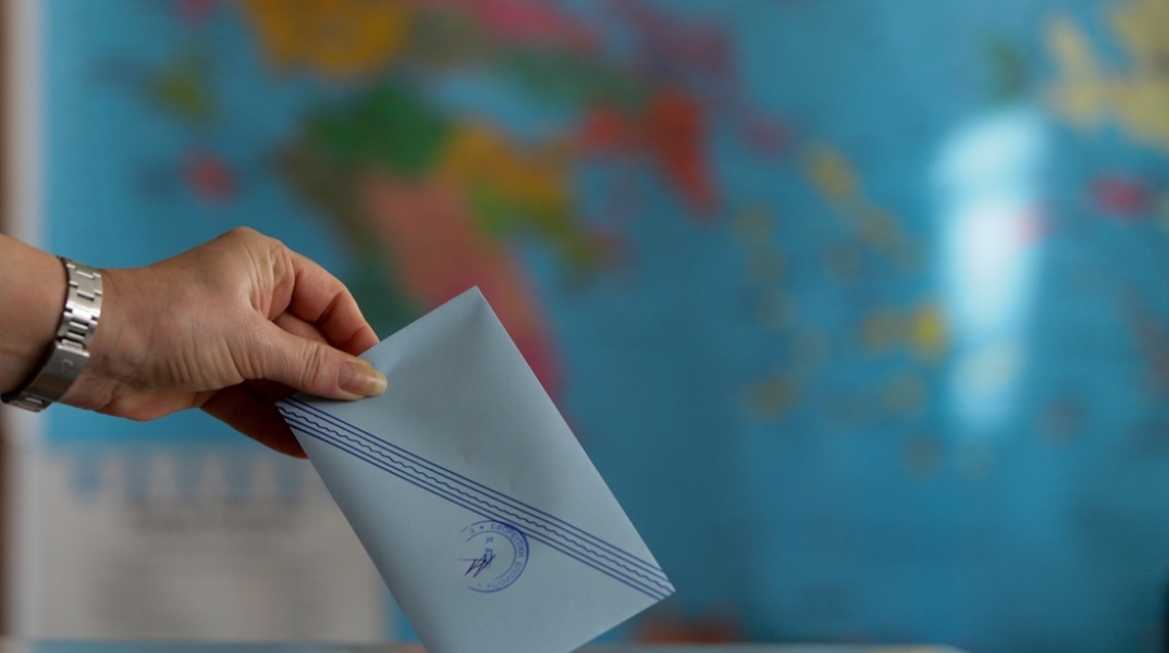 Χέρι ρίχνει τον φάκελο με το ψηφοδέλτιο στην κάλπη