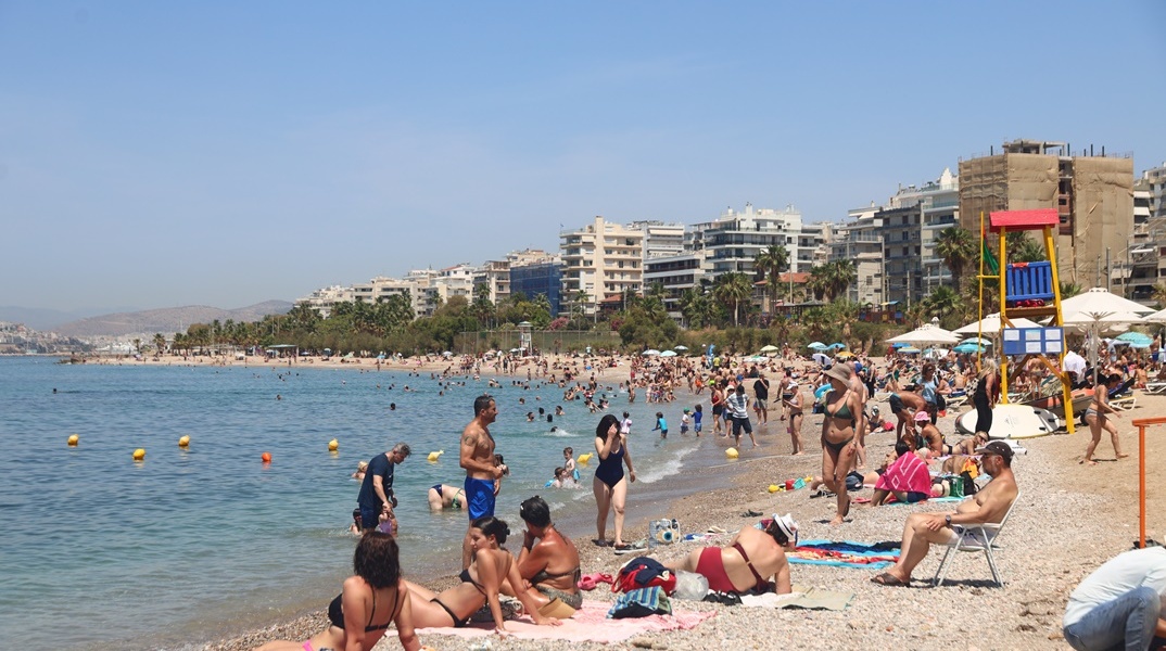 Λουόμενοι απολαμβάνουν στιγμές δροσιάς σε παραλία στην Αττική
