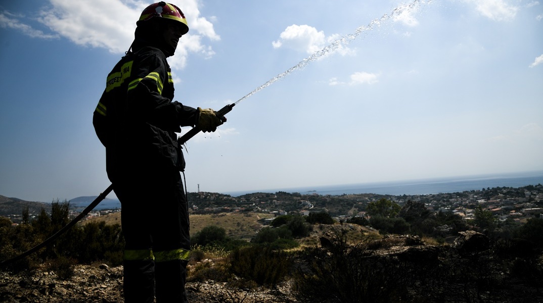 Πυροσβέστης με μάνικα ανά χείρας κατά τη διάρκεια κατάσβεσης