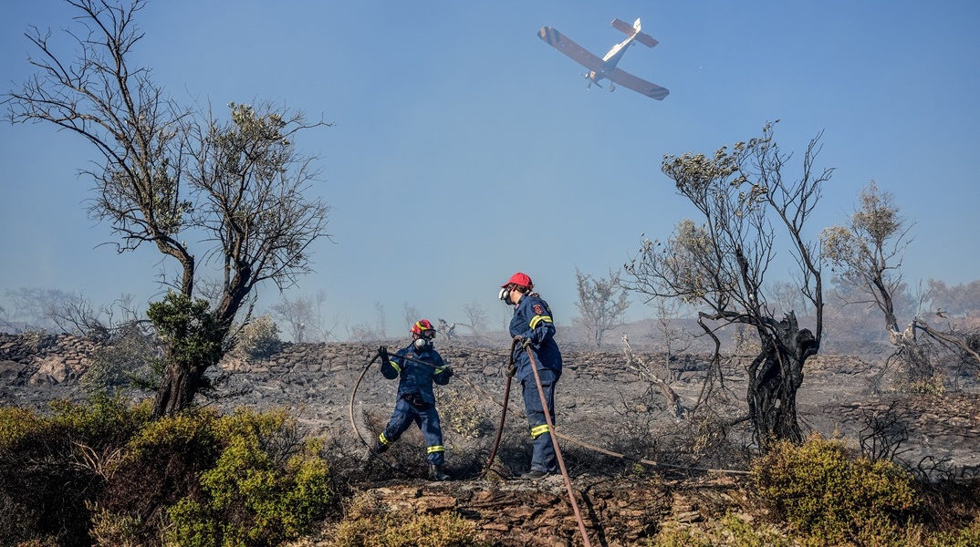 Πυροσβέστης και πυροσβεστικά αεροσκάφη σε επιχείρηση κατάσβεσης φωτιάς