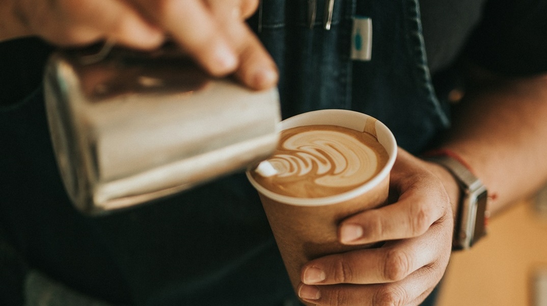 Μπαρίστα φτιάχνει καφέ σε συσκευασία take away