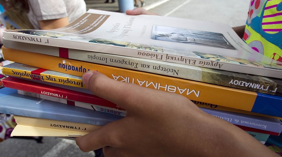 Σχολικά βιβλία στα χέρια μαθητή