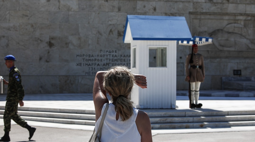 Γυναίκα κρατά το πρόσωπό της πάνω από τα μάτια της για να προφυλαχτεί από τον ήλιο εν μέσω καύσωνα © ΜΑΡΙΑΝΘΗ ΤΣΟΜΠΑΝΟΠΟΥΛΟΥ/EUROKINISSI