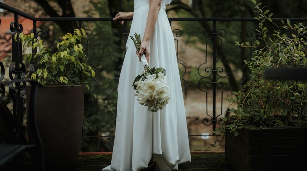 Γυναίκα με νυφικό και ανθοδέσμη