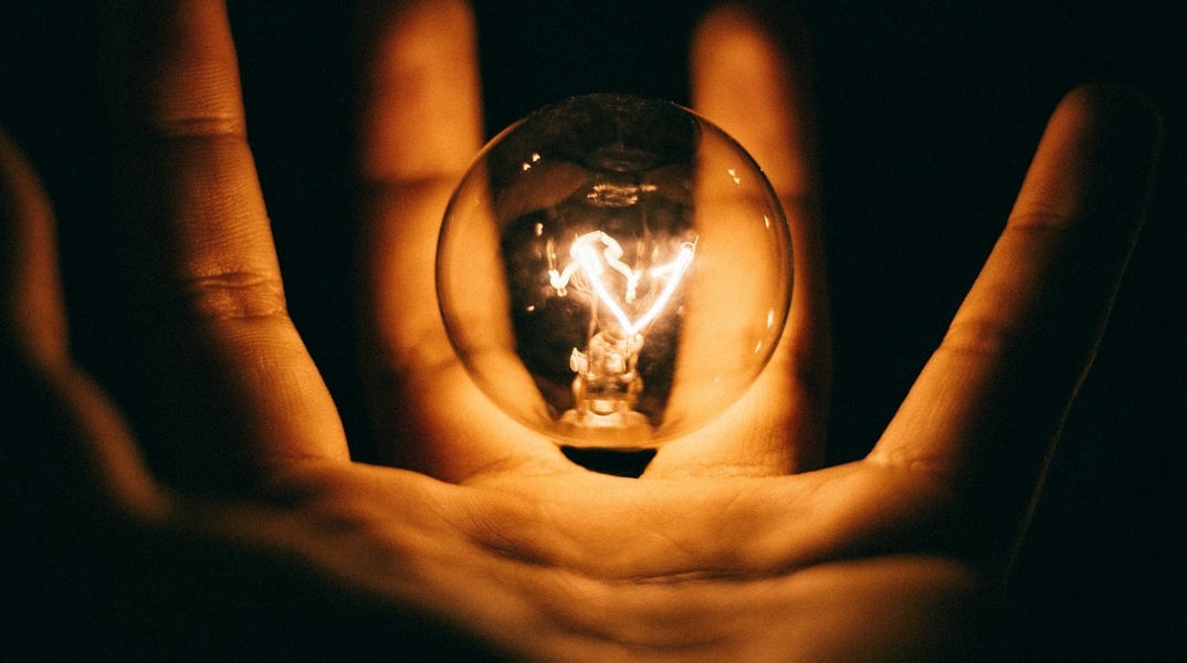 Αναμμένη λάμπα στα χέρια ατόμου