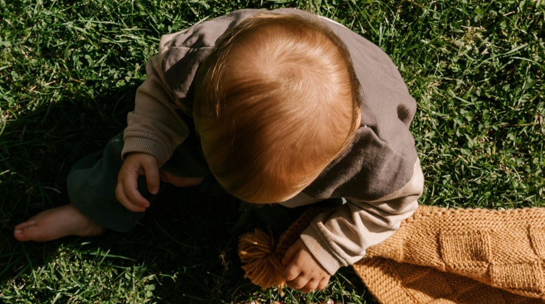 Μωρό καθισμένο στο γρασίδι