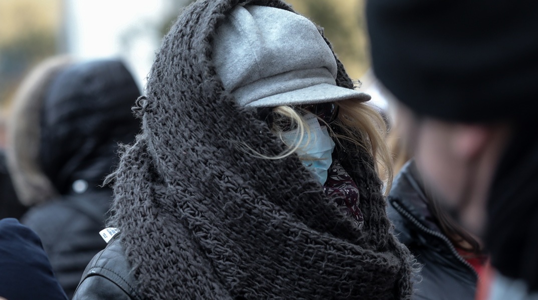 Γυναίκα με σκουφί και κασκόλ προστατεύεται από το κρύο