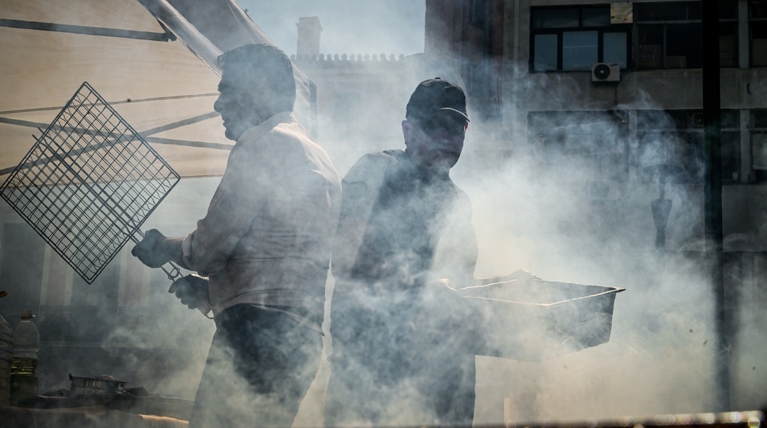 Τσίκνα από ψήσιμο και δύο άνθρωποι που ψήνουν