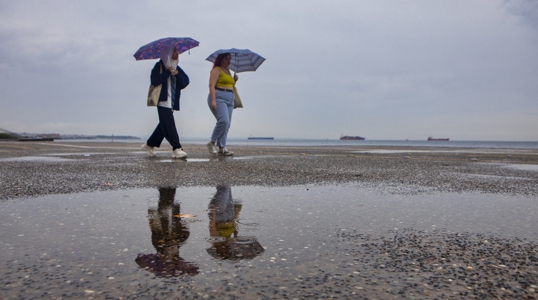 Πολίτες με ομπρέλες στην παραλία της Θεσσαλονίκης