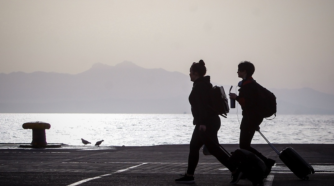 Πολίτες με βαλίτσες σε λιμάνι
