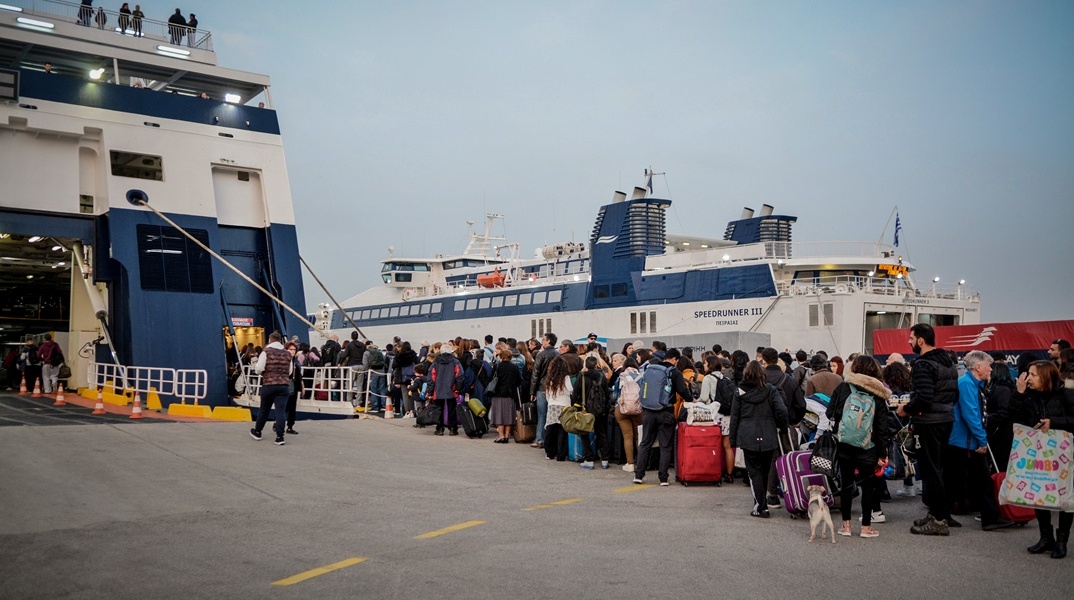Επιβάτες σχηματίζουν ουρά έξω από πλοίο στο λιμάνι του Πειραιά