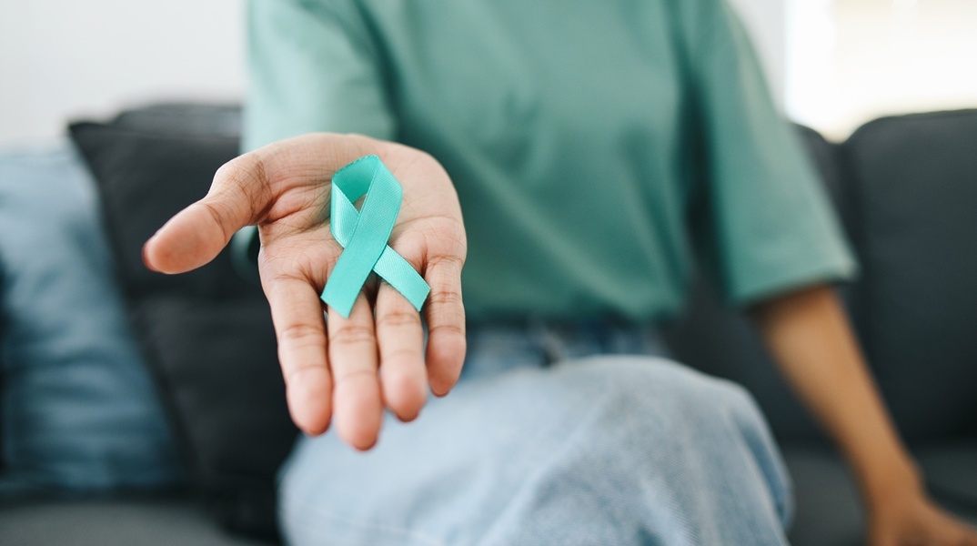 Γυναίκα κρατά φιόγκο για τον καρκίνο του τραχήλου της μήτρας