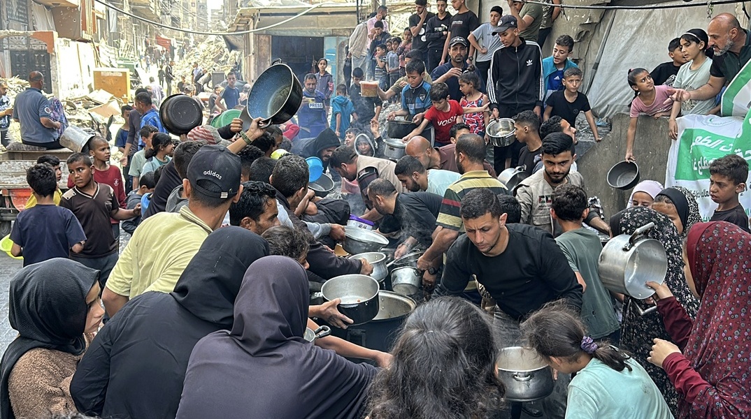 Πολίτες με κατσαρολάκια και μπολ ζητούν φαγητό σε πλατεία στη Γάζα
