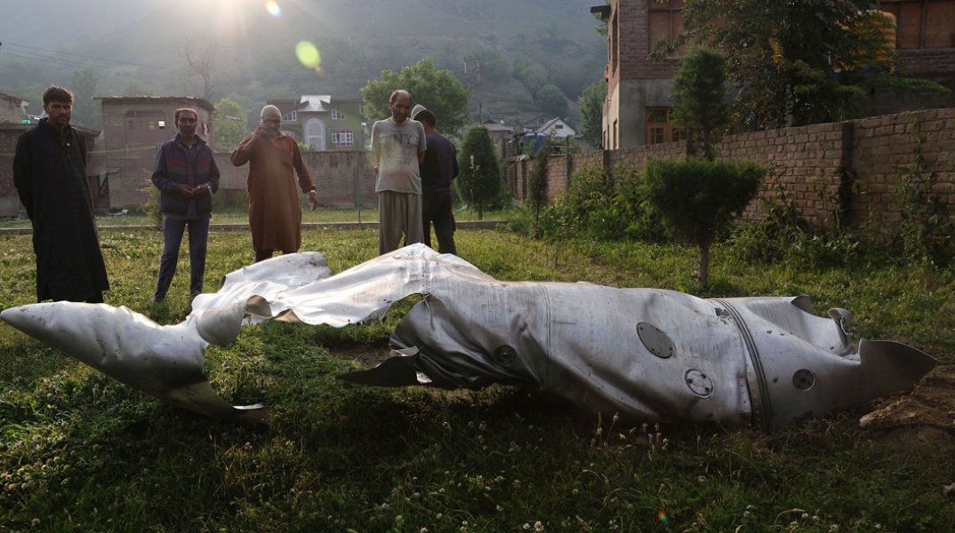 Άνθρωποι στέκονται κοντά στο κατεστραμμένο τμήμα ενός άγνωστου αεροσκάφους