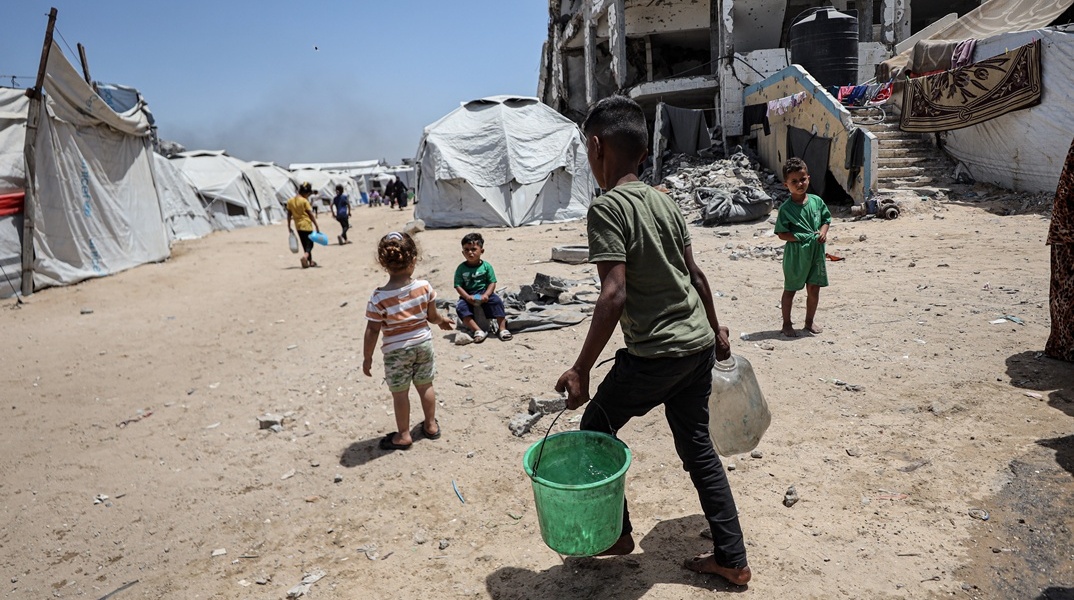 Πολίτες στη Γάζα κουβαλούν νερό με λεκάνες