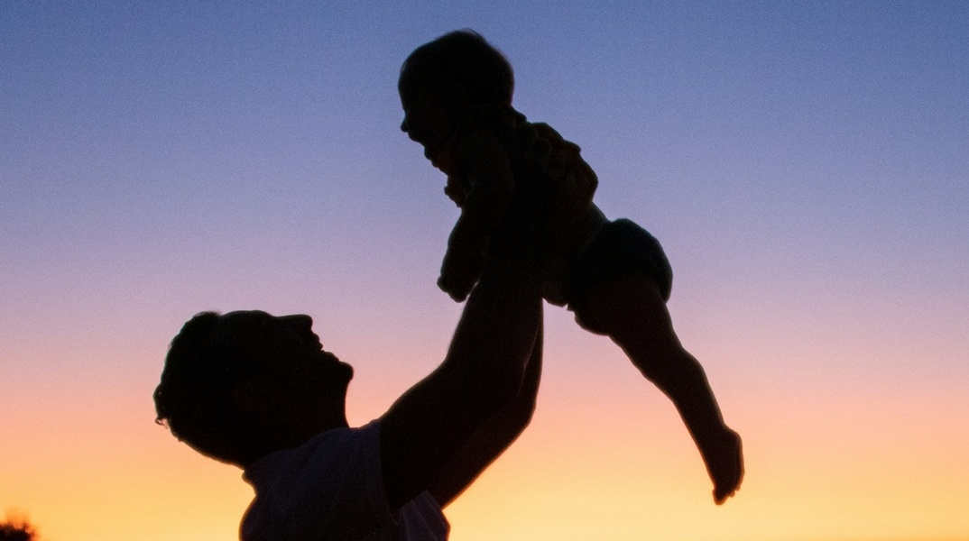 Πατέρας κρατά το μωρό του ψηλά