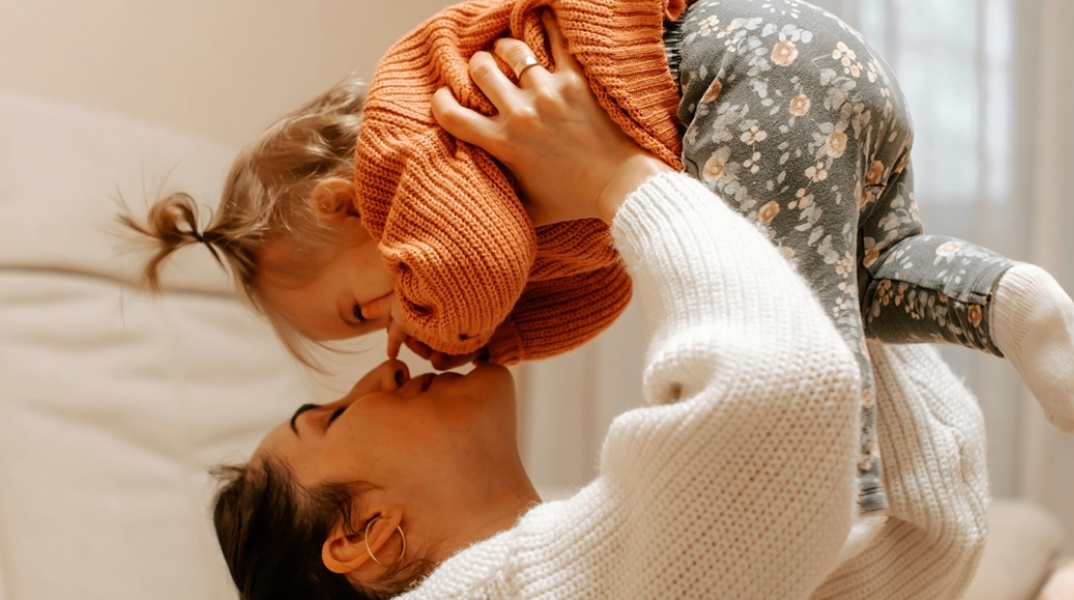 Μητέρα κρατά ψηλά το παιδάκι της