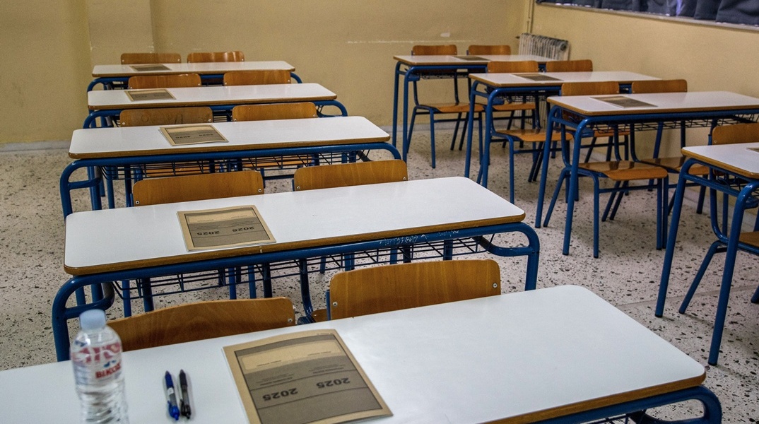 Θρανία σε εξεταστικά κέντρα με το τετράδιο απαντήσεων των Πανελληνίων 2025 τοποθετημένο πάνω τους