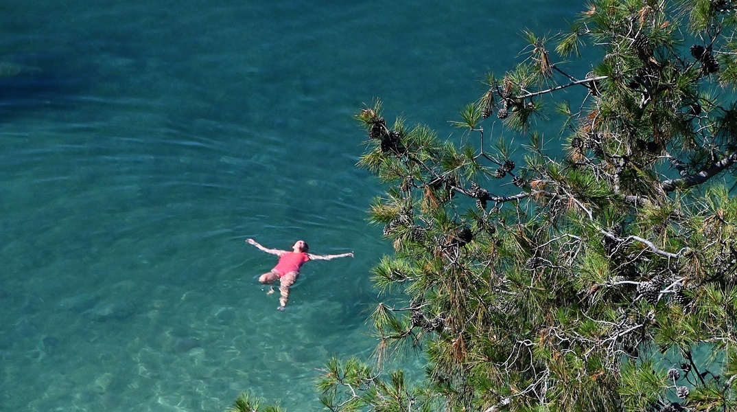 Γυναίκα απολαμβάνει το μπάνιο της στη θάλασσα