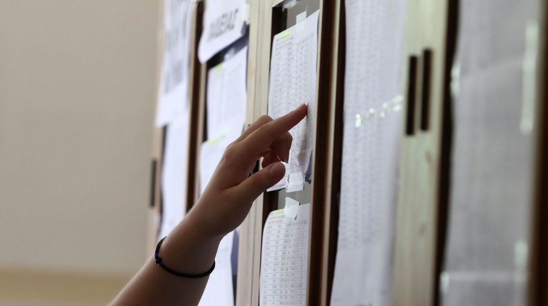 Υποψήφιοι των Πανελληνίων διαβάζουν τα αποτελέσματα έξω από σχολείο