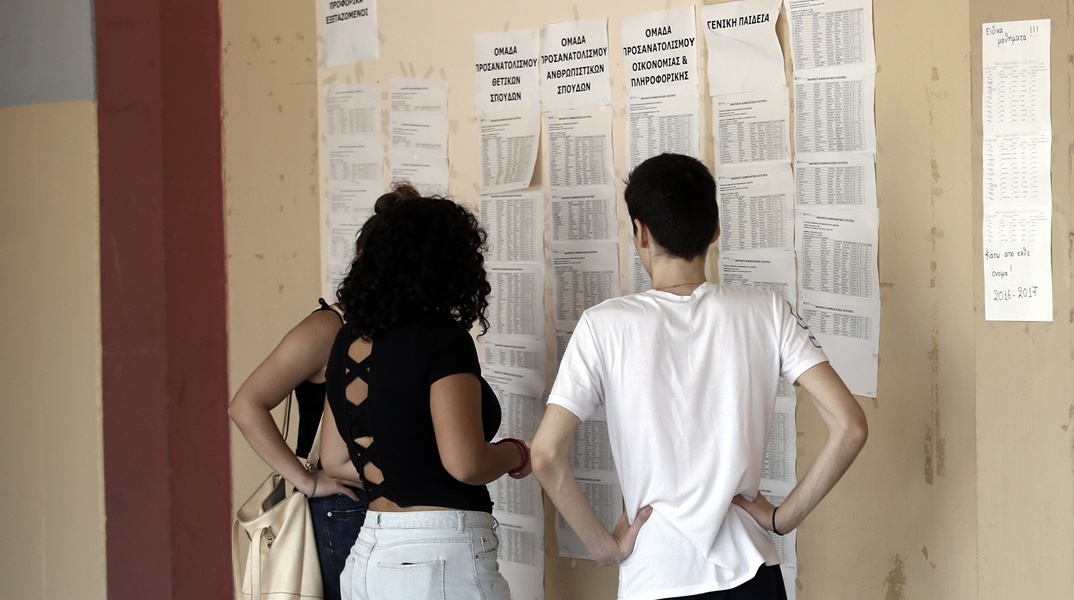 Μαθητές διαβάζουν τις τοιχοκολλημένες βάσεις των Πανελληνίων