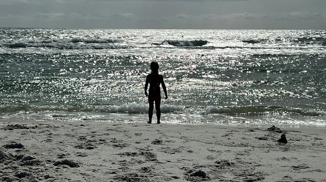 Παιδί στην άκρη της αμμουδιάς κοιτά την αγριεμένη θάλασσα