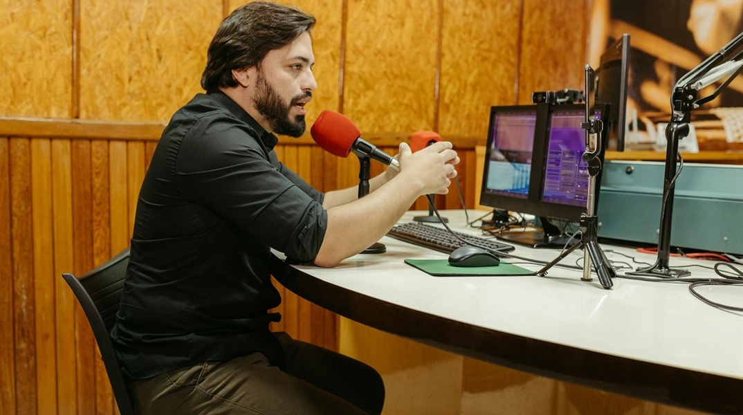 Άτομο σε στούντιο μπροστά από δύο μικρόφωνα