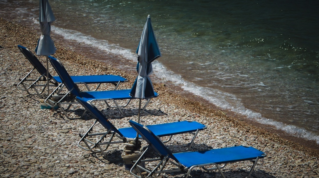 Ξαπλώστρες σε παραλία δίπλα στο κύμα