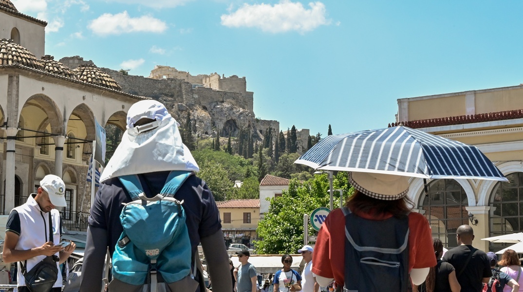 Πολίτες με καπέλα εν μέσω καύσωνα στο κέντρο της Αθήνας
