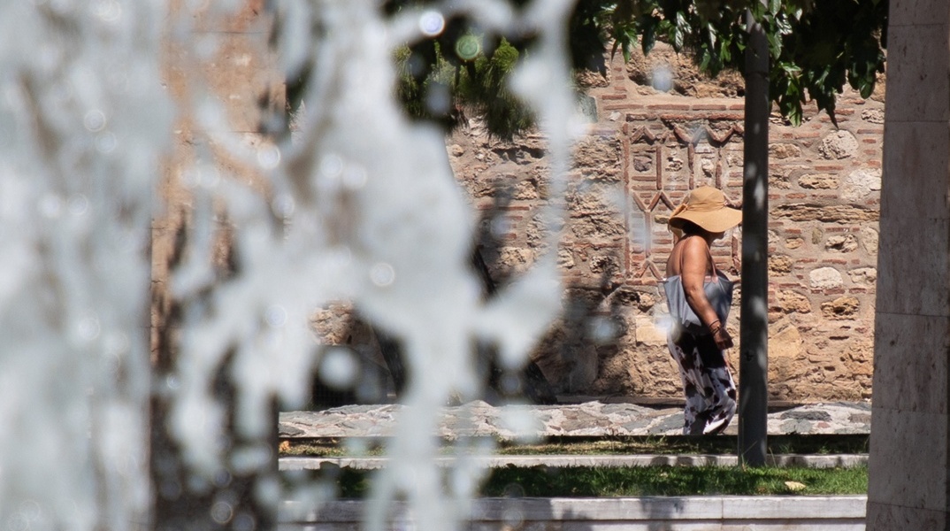 Άτομο δίπλα σε συντριβάνι υπό συνθήκες καύσωνα