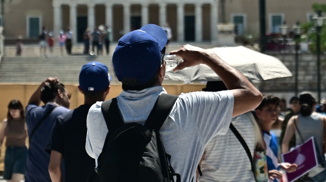 Άτομο πίνει νερό εν μέσω καύσωνα