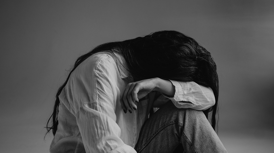 Γυναίκα κρύβει το πρόσωπό της