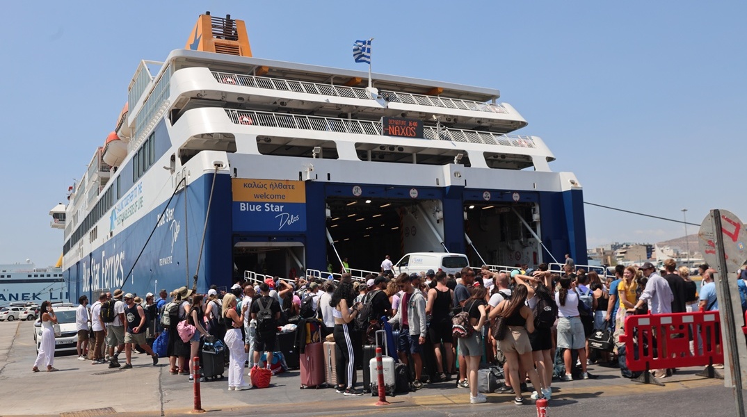 Επιβάτες ετοιμάζονται να επιβιβαστούν σε πλοίο στο λιμάνι του Πειραιά