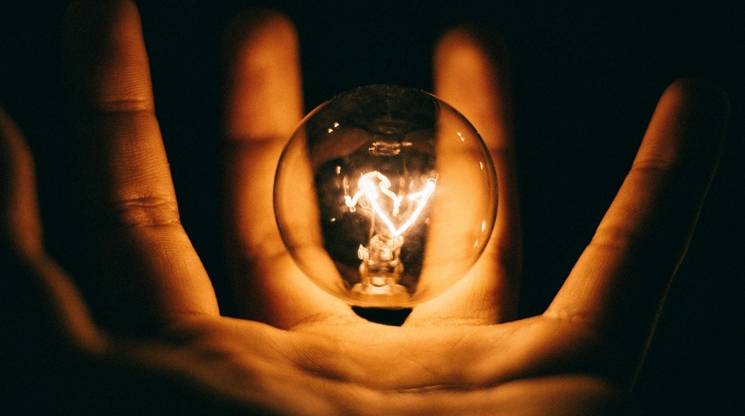 Αναμένη λάμπα σε χέρι ατόμου