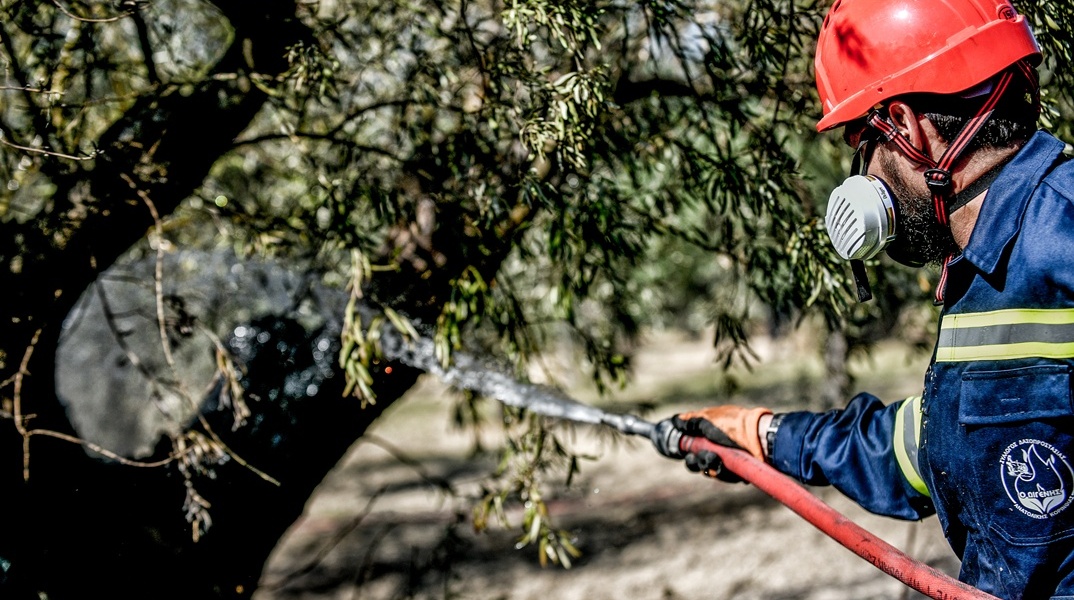 Πυροσβέστης με τη μάνικα ανά χείρας