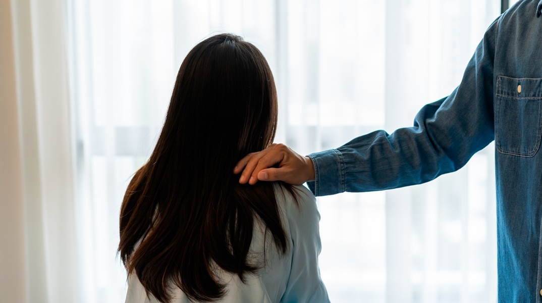 Χέρι άνδρα πάνω στον ώμο γυναίκας