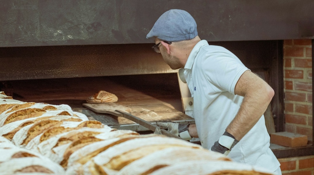 Φούρναρης βάζει ψωμιά στον φούρνο