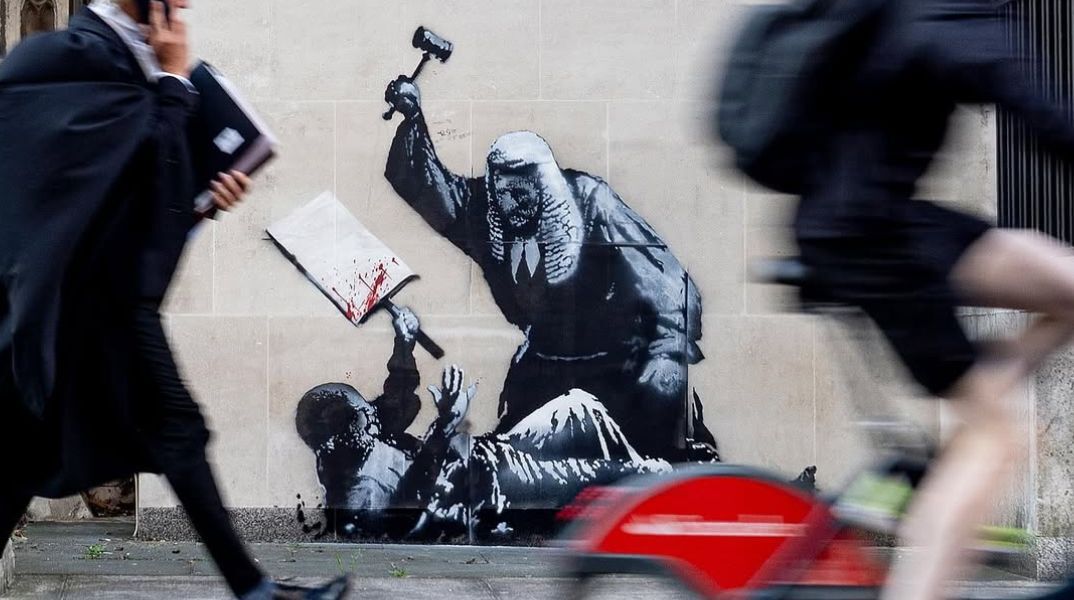 Έργο του Banksy με δικαστή να χτυπά διαδηλωτή εμφανίστηκε στο Βασιλικό Δικαστικό Μέγαρο του Λονδίνου και καλύφθηκε αμέσως από τους φρουρούς του κτιρίου. 