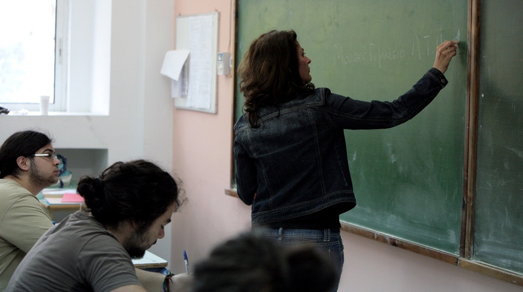 Καθηγήτρια γράφει σε πίνακα και από κάτω την παρακολουθούν μαθητές