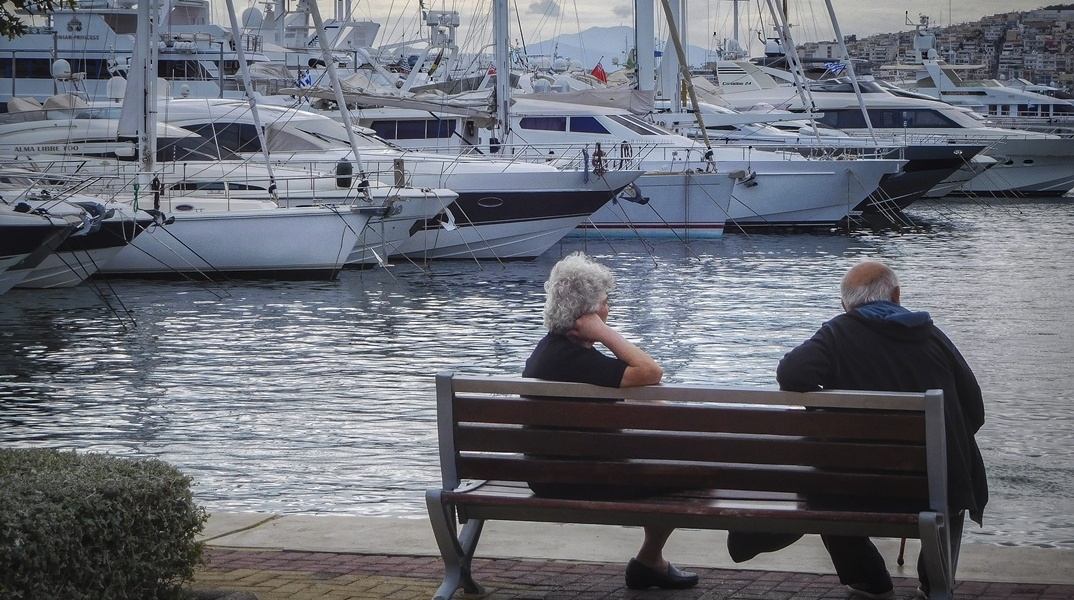 Συνταξιούχοι καθισμένο σε παραθαλάσσιο παγκάκι
