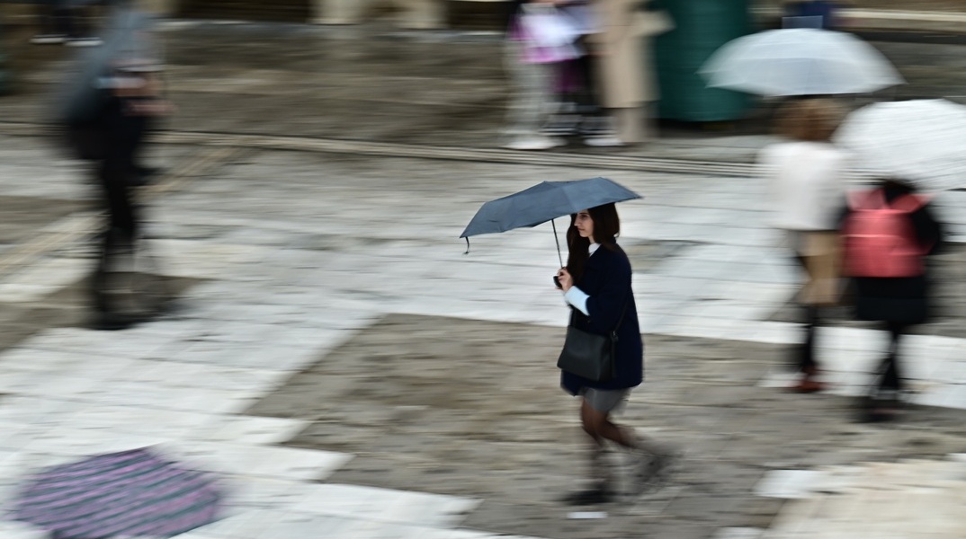 Κοπέλα με ζακέτα και ομπρέλα