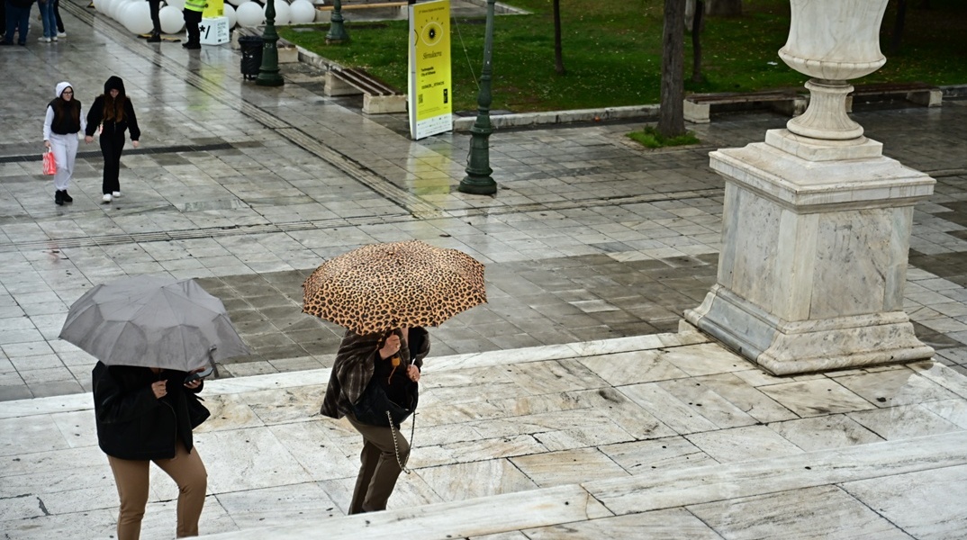 Πολίτες με ομπρέλες στο κέντρο της Αθήνας