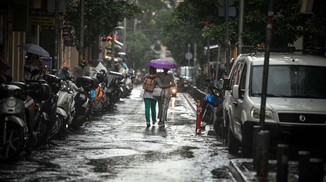 Γυναίκες κατώ από ομπρέλα εν μέσω καταιγίδας