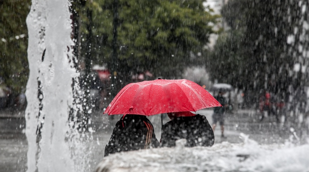 Πολίτες κρατούν ομπρέλα εν μέσω κακοκαιρίας