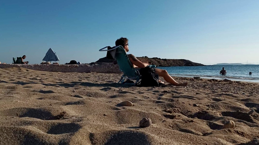 Άτομο κάνει ηλιοθεραπεία στην παραλία