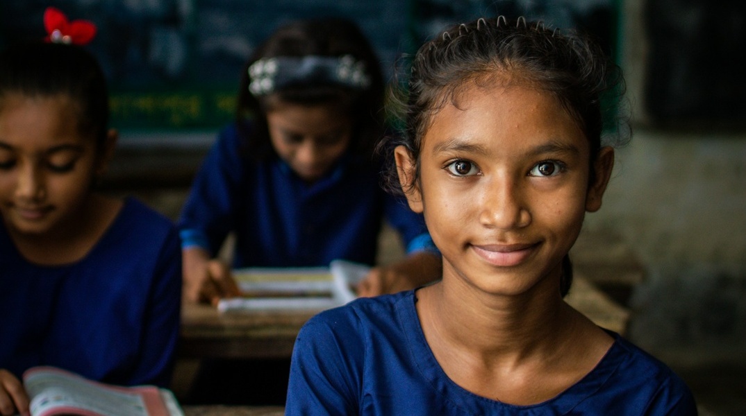 Κορίτσι σε αίθουσα σχολείου χαμογελά