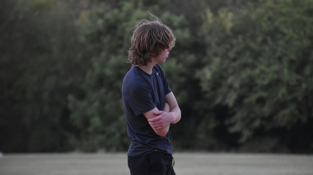 Έφηβος γυρισμένος στο πλάι ενώ στέκεται όρθιος