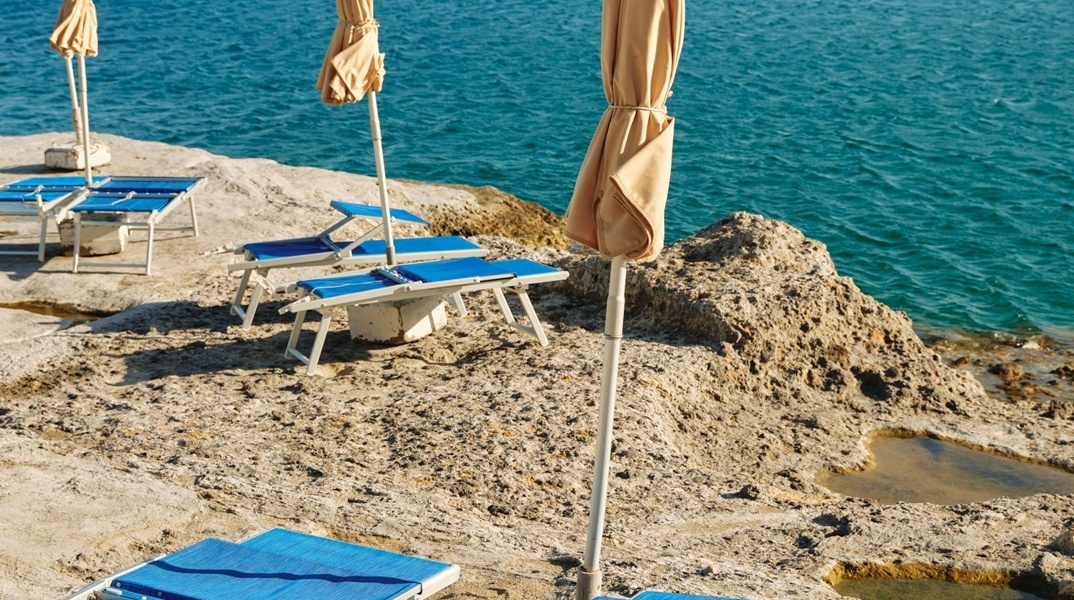 Ξαπλώστρες δίπλα σε παραλία