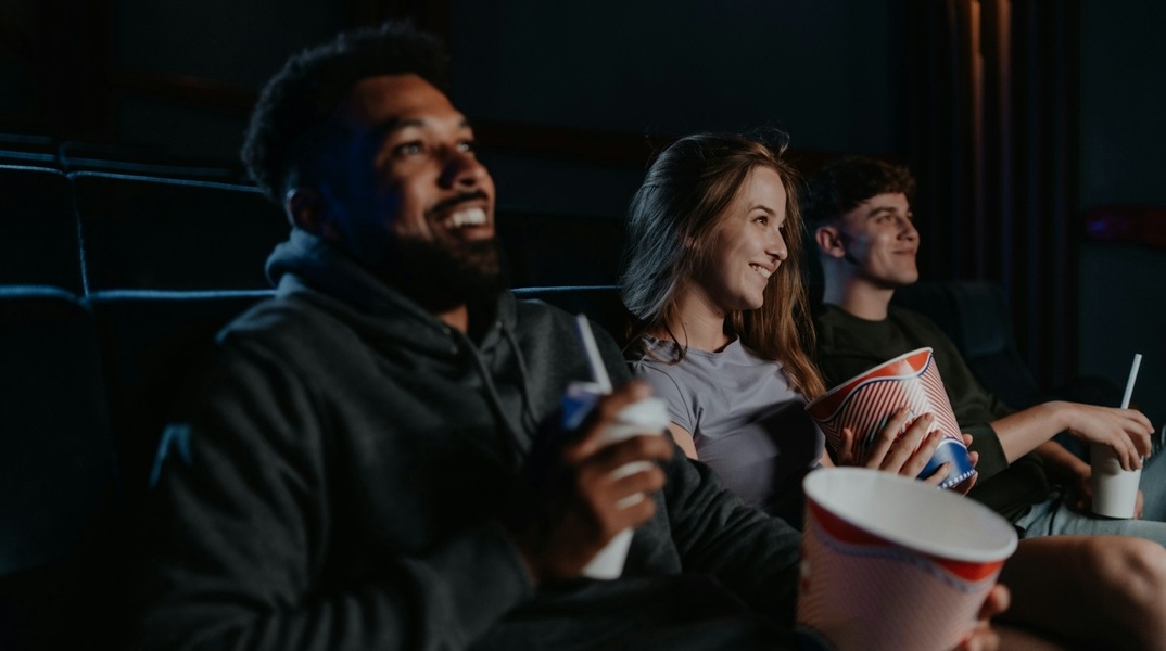Άτομα σε σινεμά με ποπ κορν στα χέρια