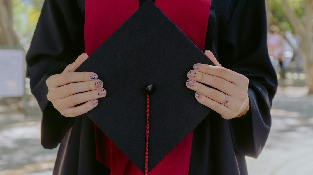 Κοπέλα με την τήβεννο στο χέρι